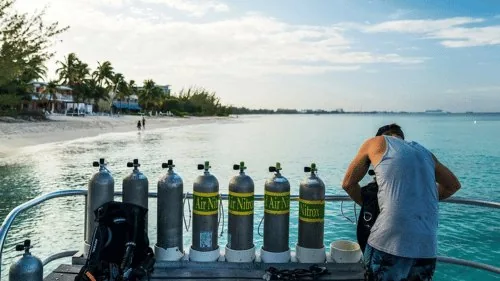 Hilera de botellas de nitrox con válvulas verdes preparadas en un barco
