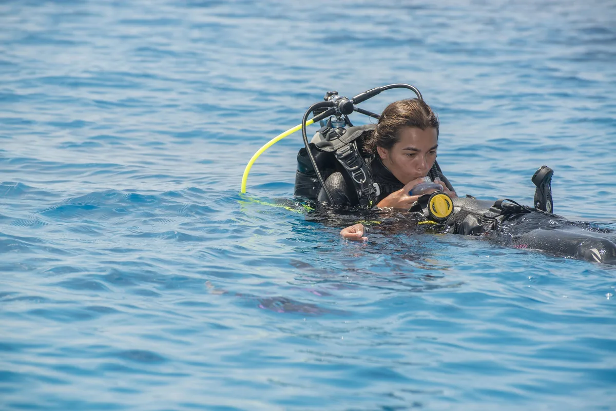 Una buceadora remolca a un compañero en la superficie del mar durante la práctica