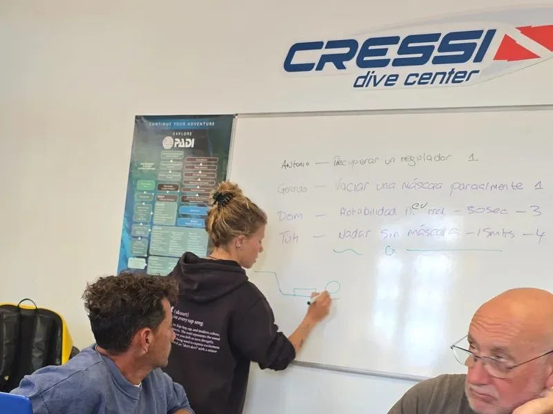 Instructora explica en la pizarra durante una clase de especialidades de instructor
