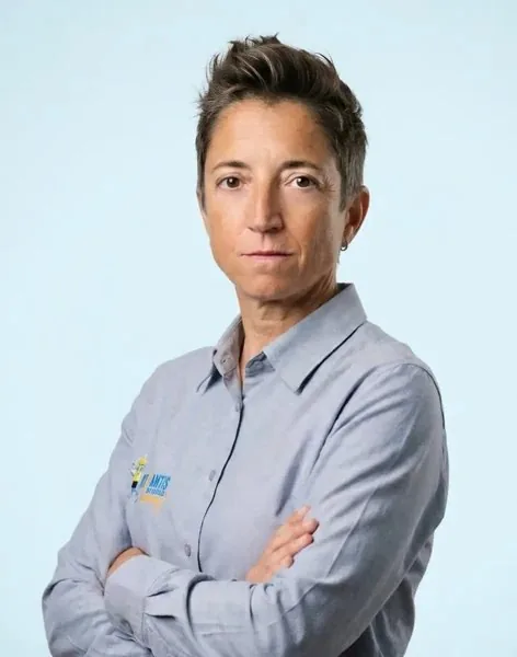 Nuria Olivé, PADI Course Director, con camisa gris, pelo corto y brazos cruzados